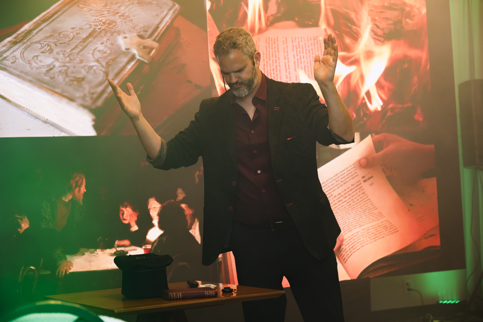 Palestrante Paul&Jack durante apresentação de palestra motivacional com técnicas de ilusionismo e vendas, diante de um telão com imagens impactantes.