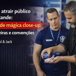 Capa de blog 16:9 com Paul à direita, em terno escuro, realizando mágica close-up com cartas nas mãos, enquanto um homem de camiseta azul observa ao lado. Fundo desfocado de evento/feira. À esquerda, texto grande: “Como atrair público no estande: show de mágica close-up para feiras e convenções – Por Paul & Jack”, com faixa vermelha destacando “show de mágica close-up”. Logo “Paul & Jack” no canto inferior esquerdo.