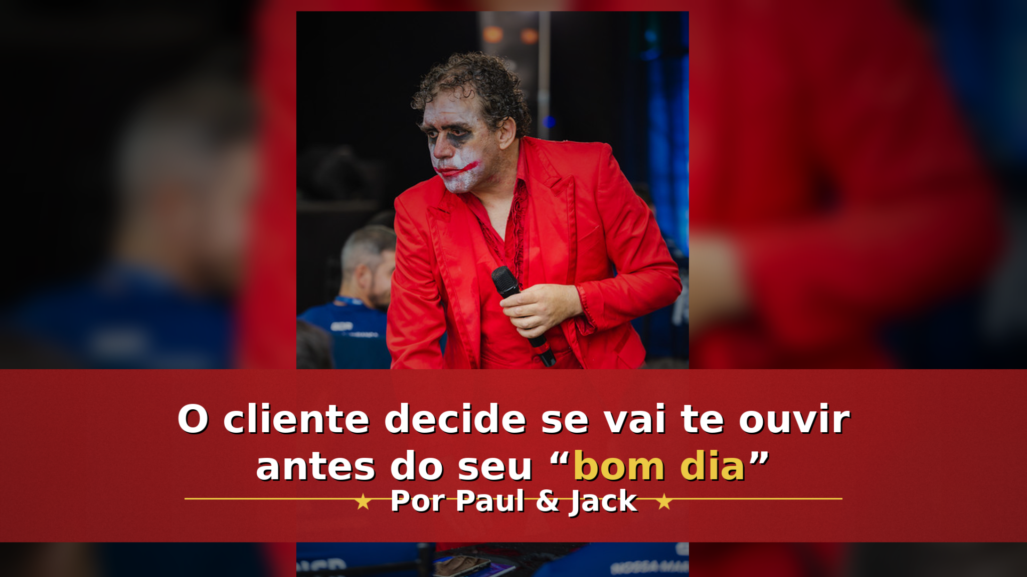Homem em um evento, vestido com terno vermelho e maquiagem de personagem, segurando um microfone e inclinando-se em direção ao público. Na parte inferior, uma faixa vermelha com o texto: “O cliente decide se vai te ouvir antes do seu ‘bom dia’” e, abaixo, “Por Paul & Jack”.