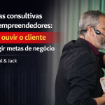 Capa de blog 16:9 com Paul à direita, de perfil, usando headset e terno escuro com camisa vinho, gesticulando enquanto segura um leque de cartas. Fundo desfocado com cortina cinza e luz verde. À esquerda, texto grande: “Vendas consultivas para empreendedores: como ouvir o cliente e atingir metas de negócio – Por Paul & Jack”, com faixa vermelha destacando “como ouvir o cliente”. Logo “Paul & Jack” no canto inferior esquerdo.