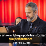 Homem palestrante em palco, segurando uma chama acesa durante demonstração ao vivo, com expressão concentrada, fundo iluminado em vermelho e título em faixa preta sobre a imagem.