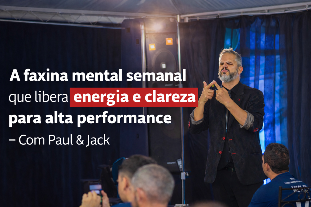 Paul em palestra ao vivo, gesticulando no palco durante apresentação sobre faxina mental semanal, foco, energia e alta performance, diante de uma plateia atenta.