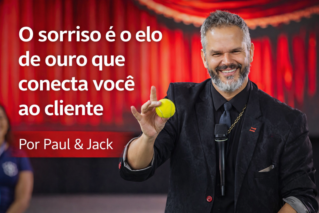 Paul, palestrante de vendas e comunicação, sorrindo no palco e segurando uma bola amarela durante uma apresentação. Imagem de capa do artigo “O sorriso é o elo de ouro que conecta você ao cliente”.