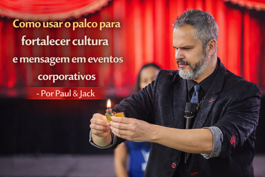 Palestrante realizando truque com fogo no palco durante evento corporativo, com o título “Como usar o palco para fortalecer cultura e mensagem em eventos corporativos – Por Paul & Jack”.