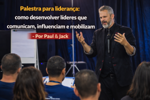 Palestrante em pé diante da plateia durante evento corporativo, gesticulando com as mãos e microfone, com o título “Palestra para liderança: como desenvolver líderes que comunicam, influenciam e mobilizam – Por Paul & Jack”.