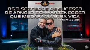 Montagem em formato 16:9 inspirada em pôster cinematográfico, mostrando Paul & Jack abraçando Arnold Schwarzenegger caracterizado como o Exterminador do Futuro. Os dois aparecem ao centro, em frente a um painel metálico vertical, com fundo de palco escuro, iluminação azul e vermelha nas laterais e telas desfocadas ao fundo. Na parte superior da imagem, há um título grande em estilo metálico: “Os 3 segredos de sucesso de Arnold Schwarzenegger que mudaram minha vida”, seguido de “- por Paul & Jack”. No topo, aparece um selo circular que remete à estética de capa de DVD.