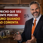 Capa de blog em formato 16:9 com um homem de terno escuro e gravata laranja em destaque, sorrindo e gesticulando diante de um quadro branco com “5%” ao fundo. À esquerda, o título “O capricho que seu cliente percebe mesmo quando não comenta” aparece em letras grandes sobre uma faixa vermelha translúcida, com a assinatura “Por Paul & Jack” no canto inferior.