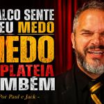 Capa de blog em formato 16:9 mostra um homem de terno preto e gravata listrada dourada, com expressão intensa, diante de uma cortina vermelha que remete a palco. À esquerda, o título em destaque diz: “O palco sente o seu medo e a plateia também - Por Paul e Jack”.