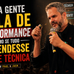capa de blog em formato 16:9 mostra Paul em primeiro plano, segurando microfone e controle de apresentação, com expressão intensa durante uma palestra. À esquerda, o título em destaque diz: “Muita gente fala de performance como se tudo dependesse só de técnica - Por Paul & Jack”.